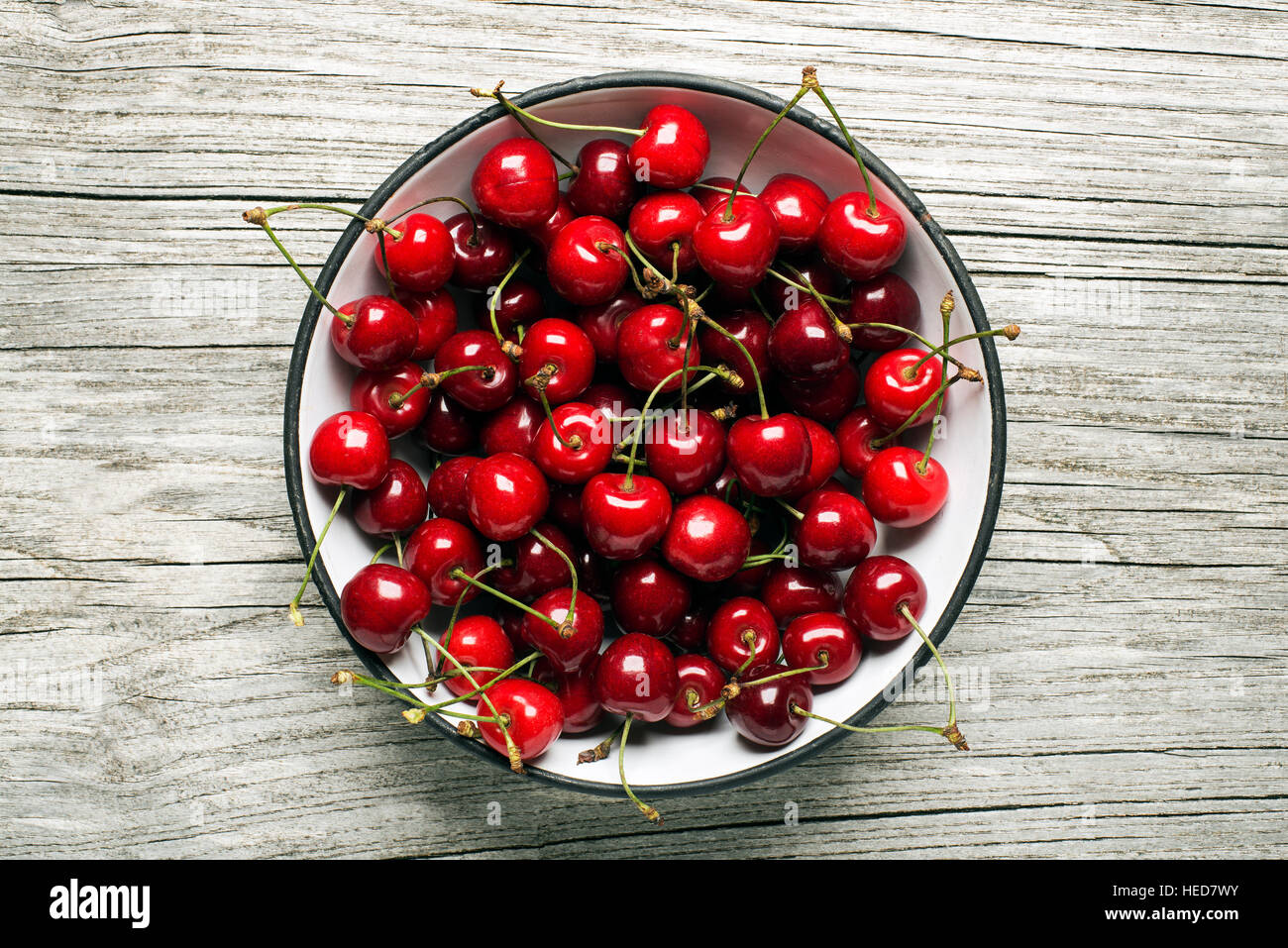 Fresh cherries in a bowl on wooden background. Stock Photo