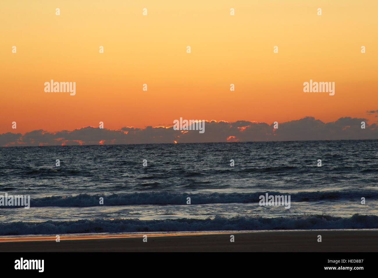 Sun coming up over the ocean at sunrise Stock Photo Alamy