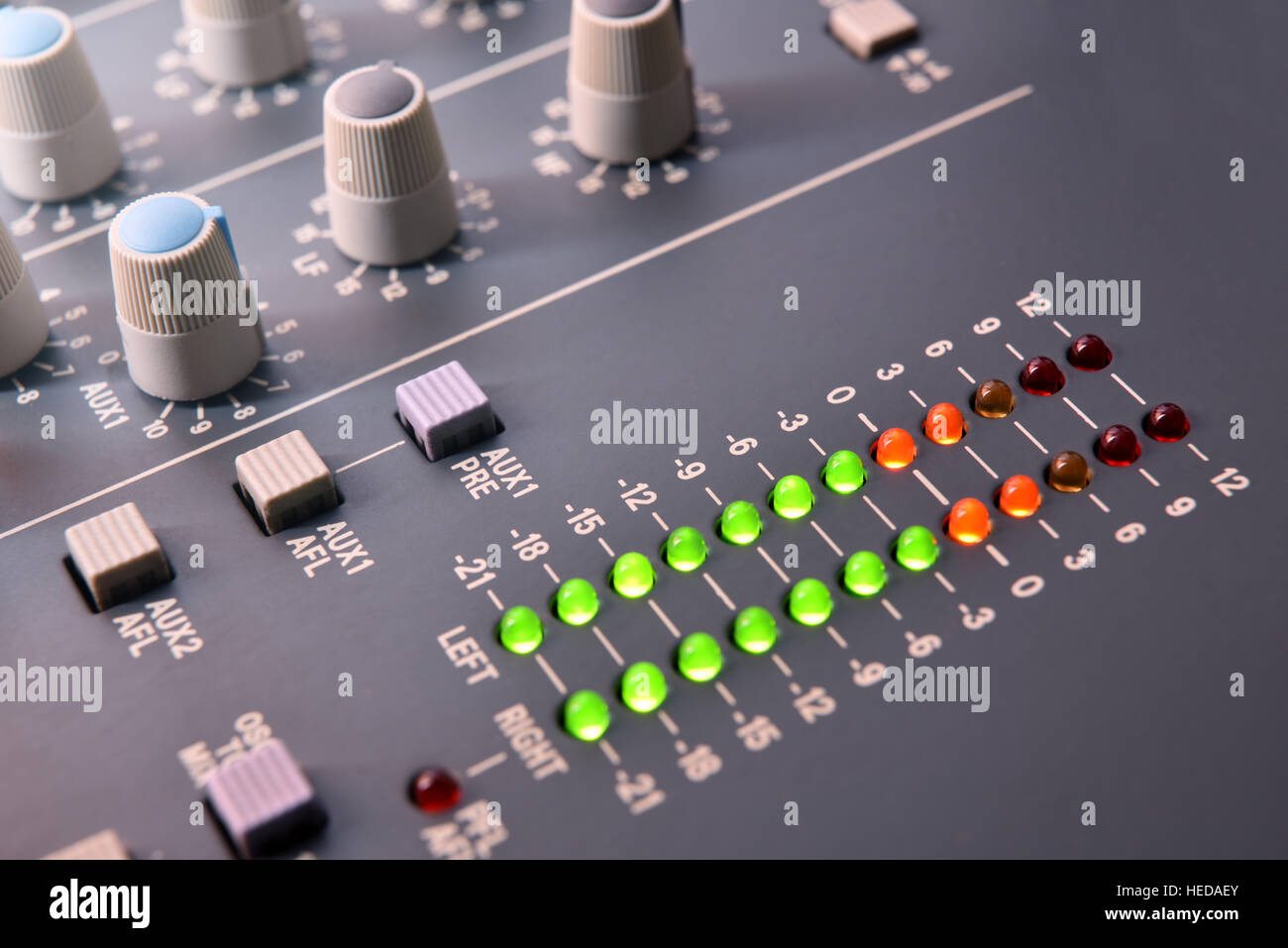 Close up buttons and digital vu-meter sound mixer on white table. Elevated view. Horizontal composition Stock Photo