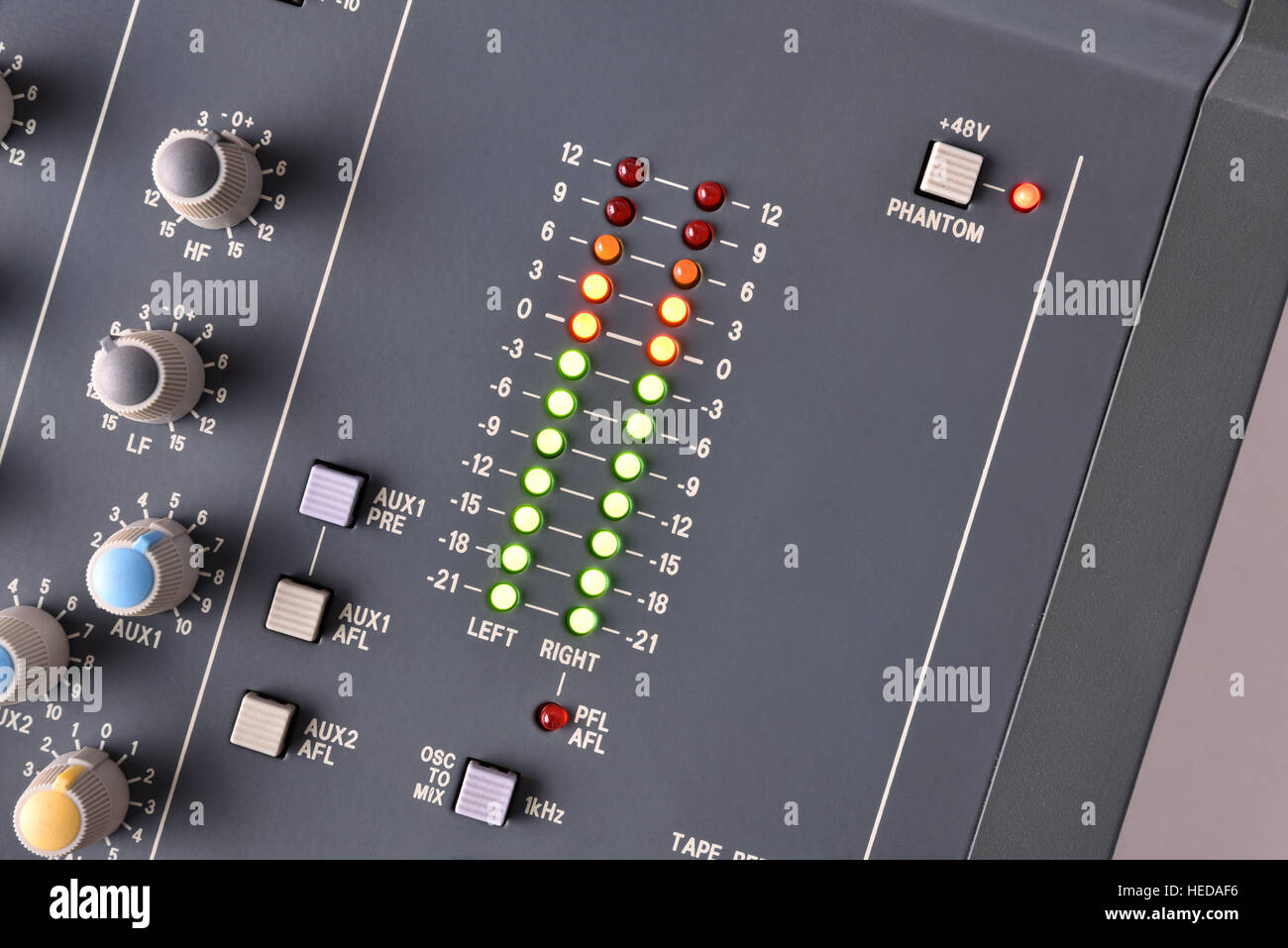 Close up buttons and digital vu-meter sound mixer on white table. Top view. Horizontal composition Stock Photo