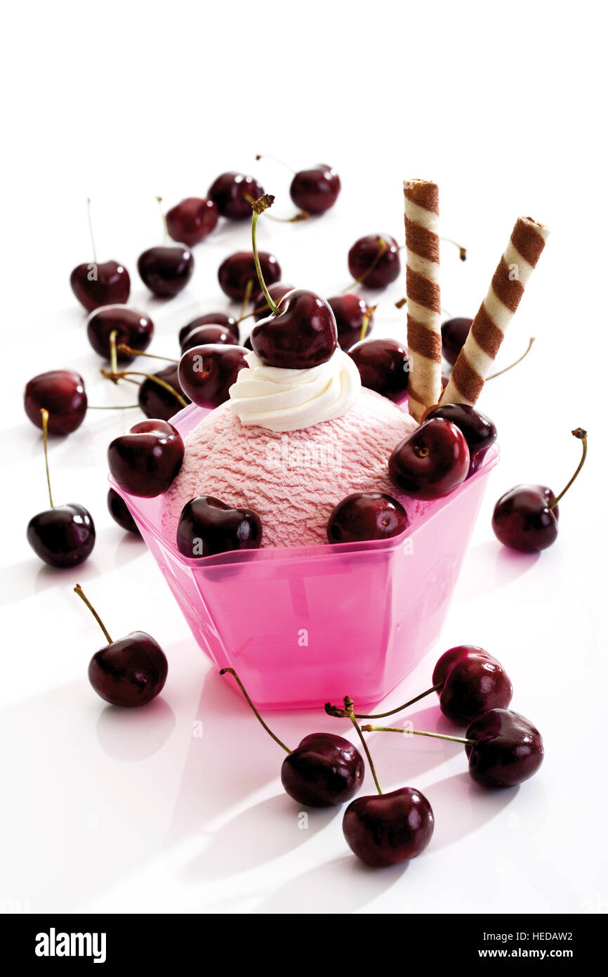 Cherry ice cream sundae topped with whipped cream, cherries and wafer