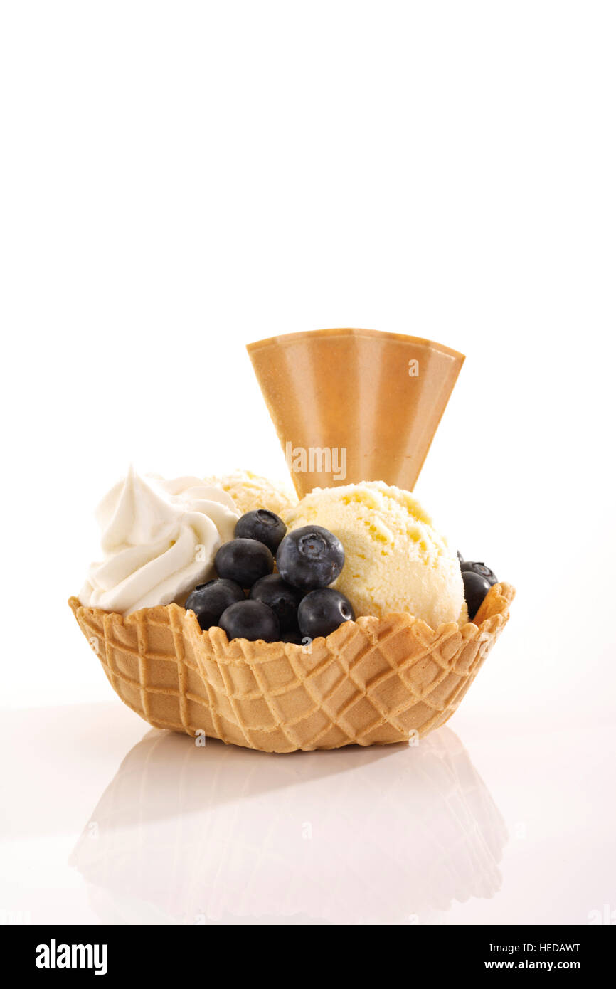 Vanilla ice cream, blueberries, whipped cream and a fanshaped wafer in