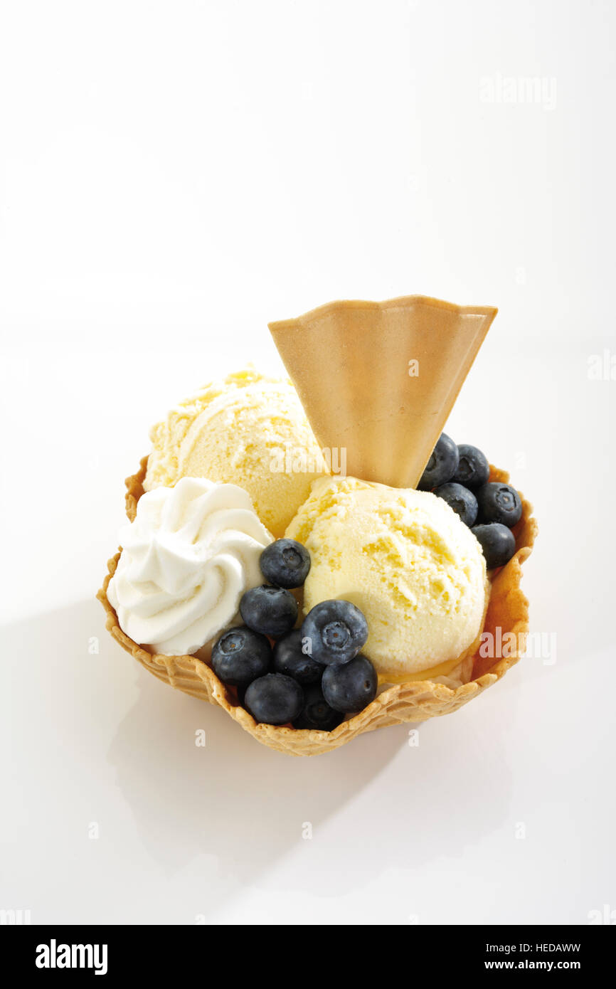 Vanilla ice cream, blueberries, whipped cream and a fan-shaped wafer in a wafer bowl Stock Photo
