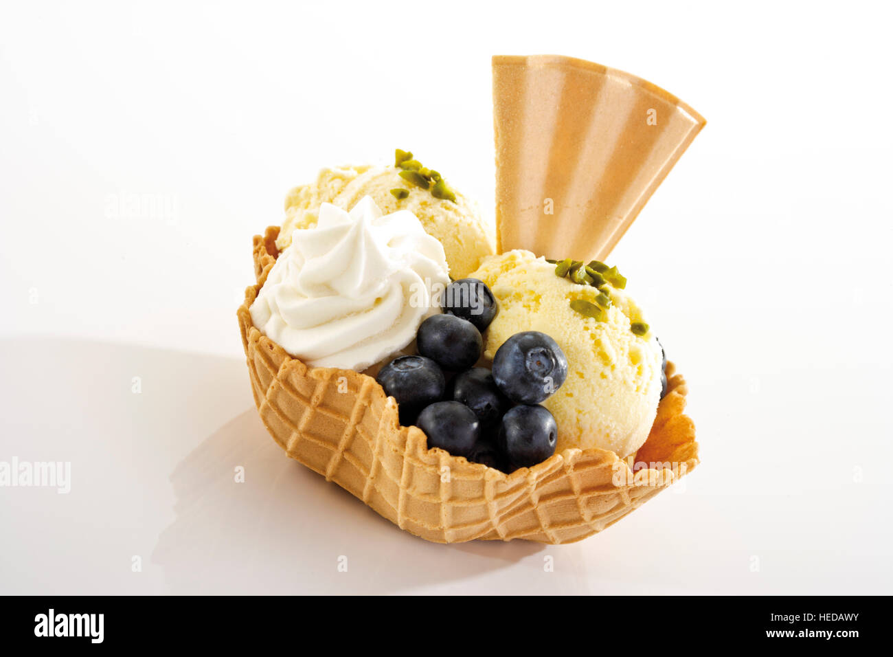 Vanilla ice cream, blueberries, whipped cream and a fan-shaped wafer in a wafer bowl Stock Photo