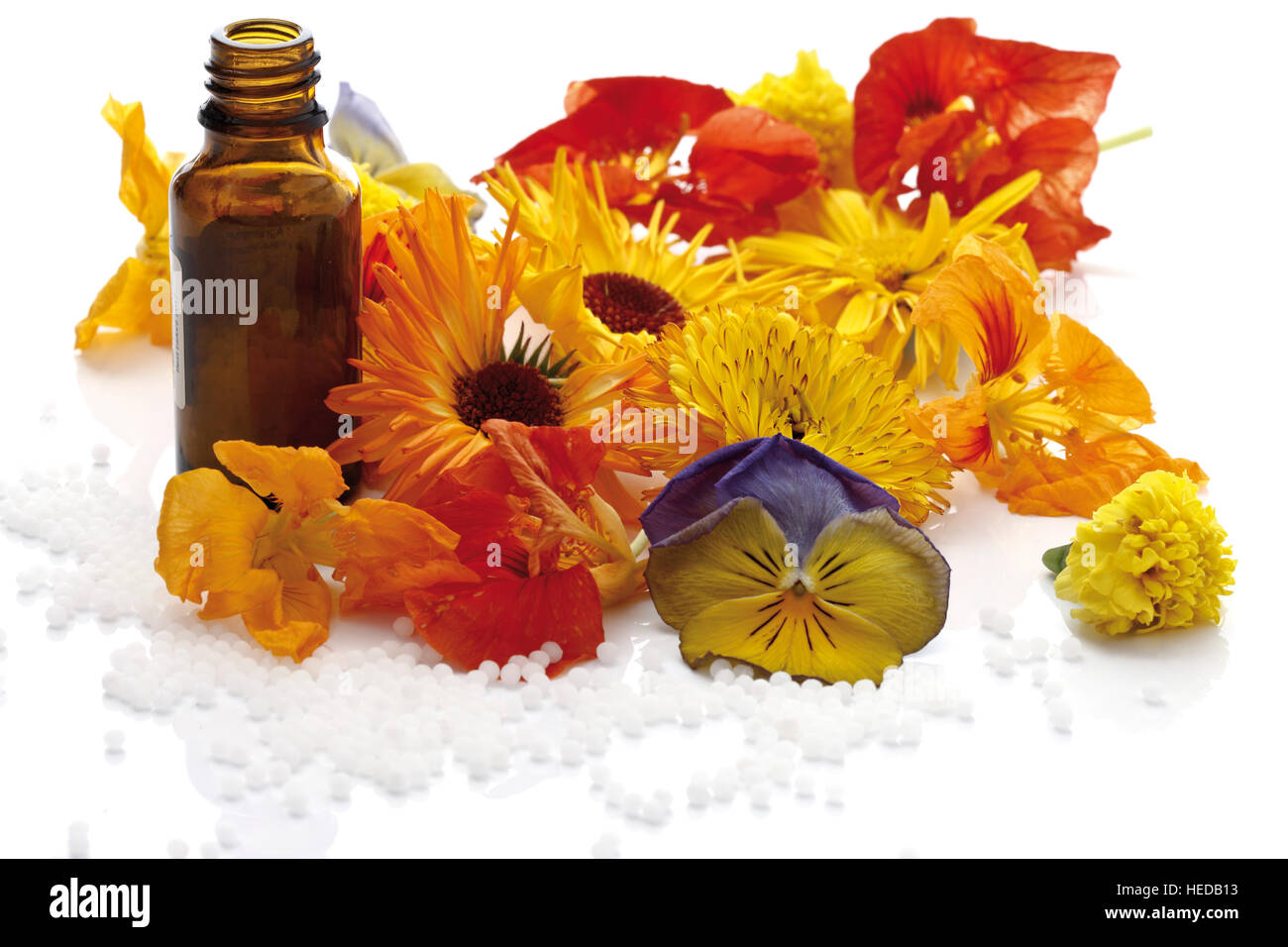 Homeopathic globules with medicinal blossoms Stock Photo