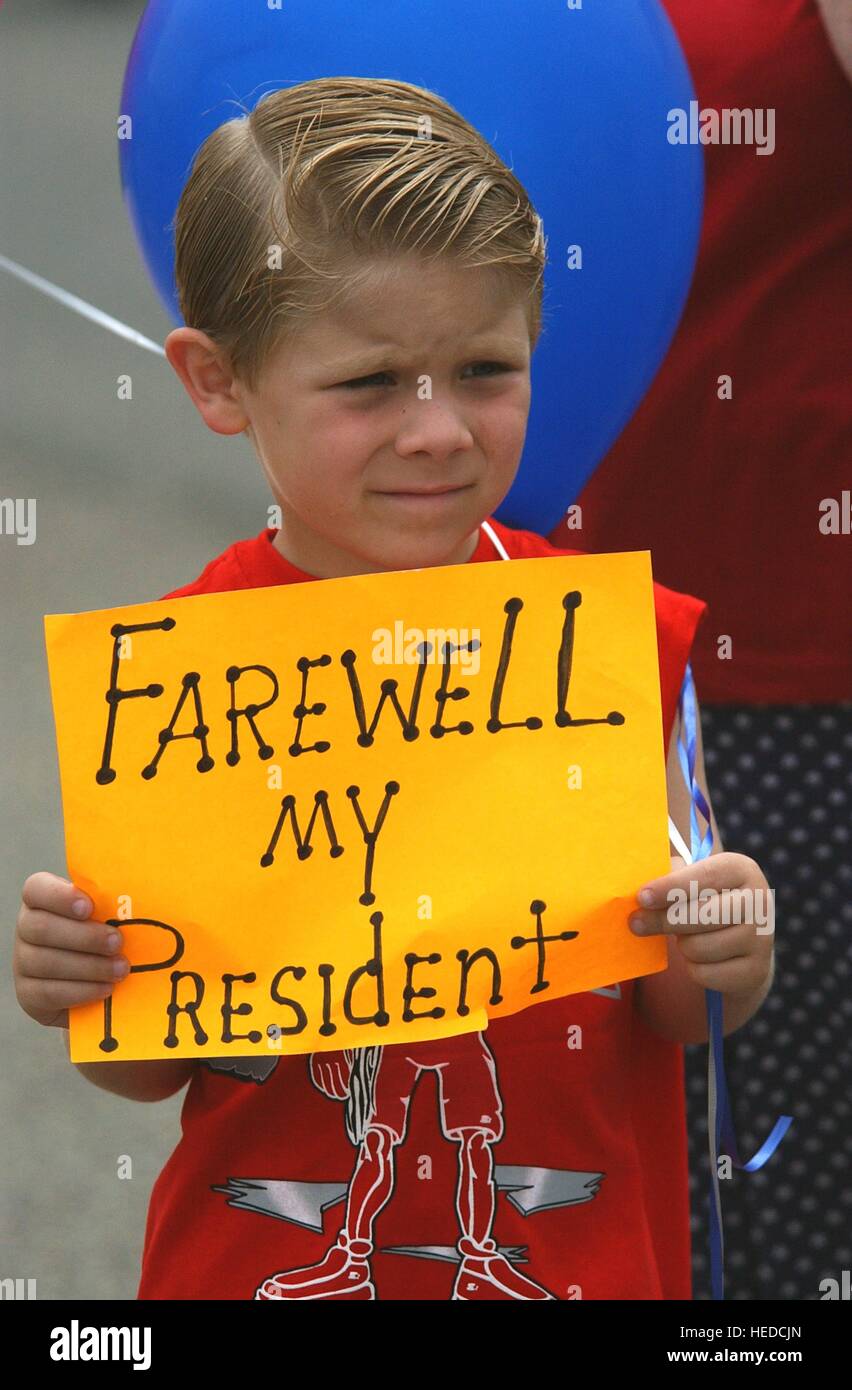 A young boy awaits the arrival of the presidential state funeral motorcade at the gates of the Ronald Reagan Presidential Library, holding a farewell sign to honor the passing of former U.S. President Ronald Reagan June 7, 2004 in Simi Valley, California. Stock Photo
