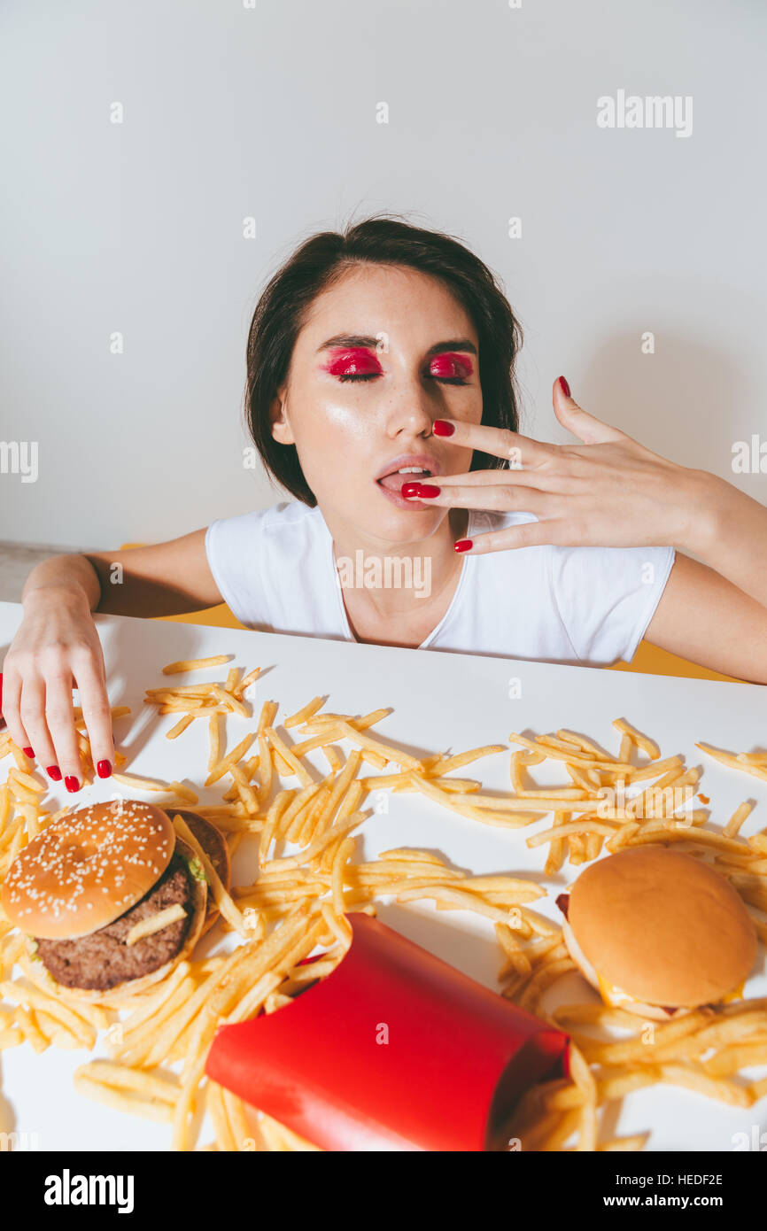 Sensual Young Woman Licking Her Finger After Eating Fast Food Over White Background Stock Photo Alamy