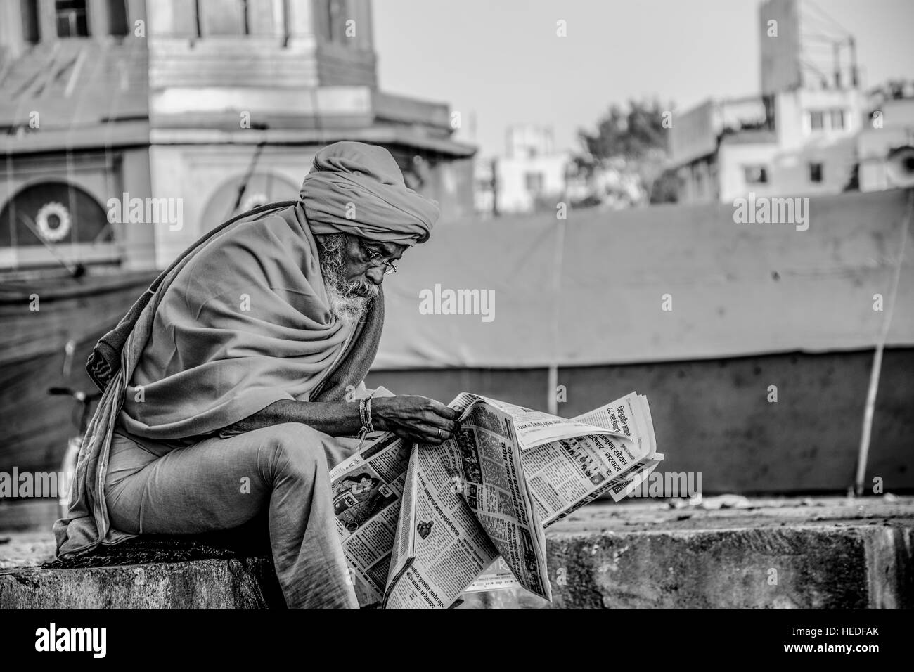 A sadhu reading newspaper. Stock Photo