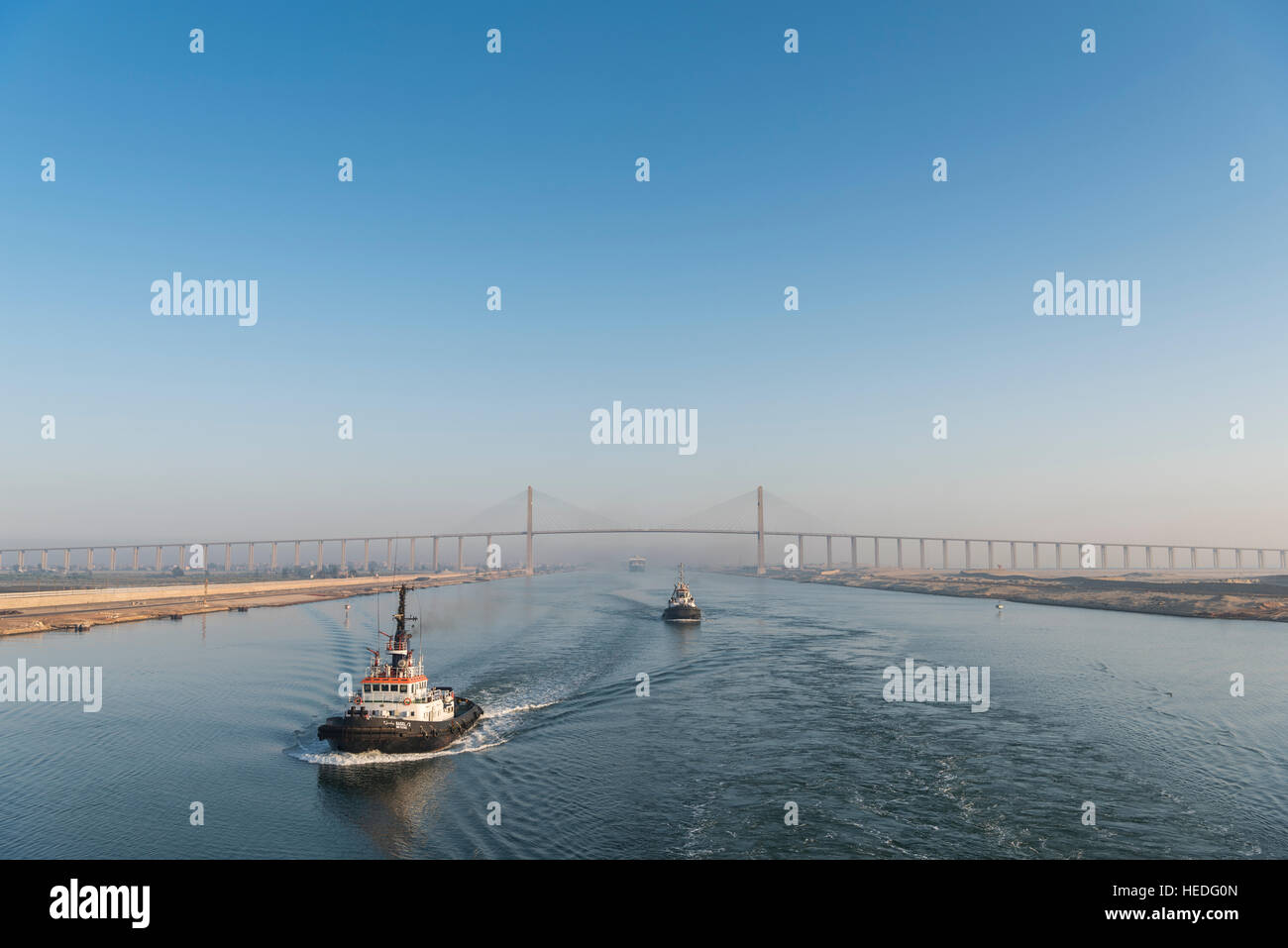 Tug Boats pass the Suez Canal Bridge at El Qantara, Egypt Stock Photo