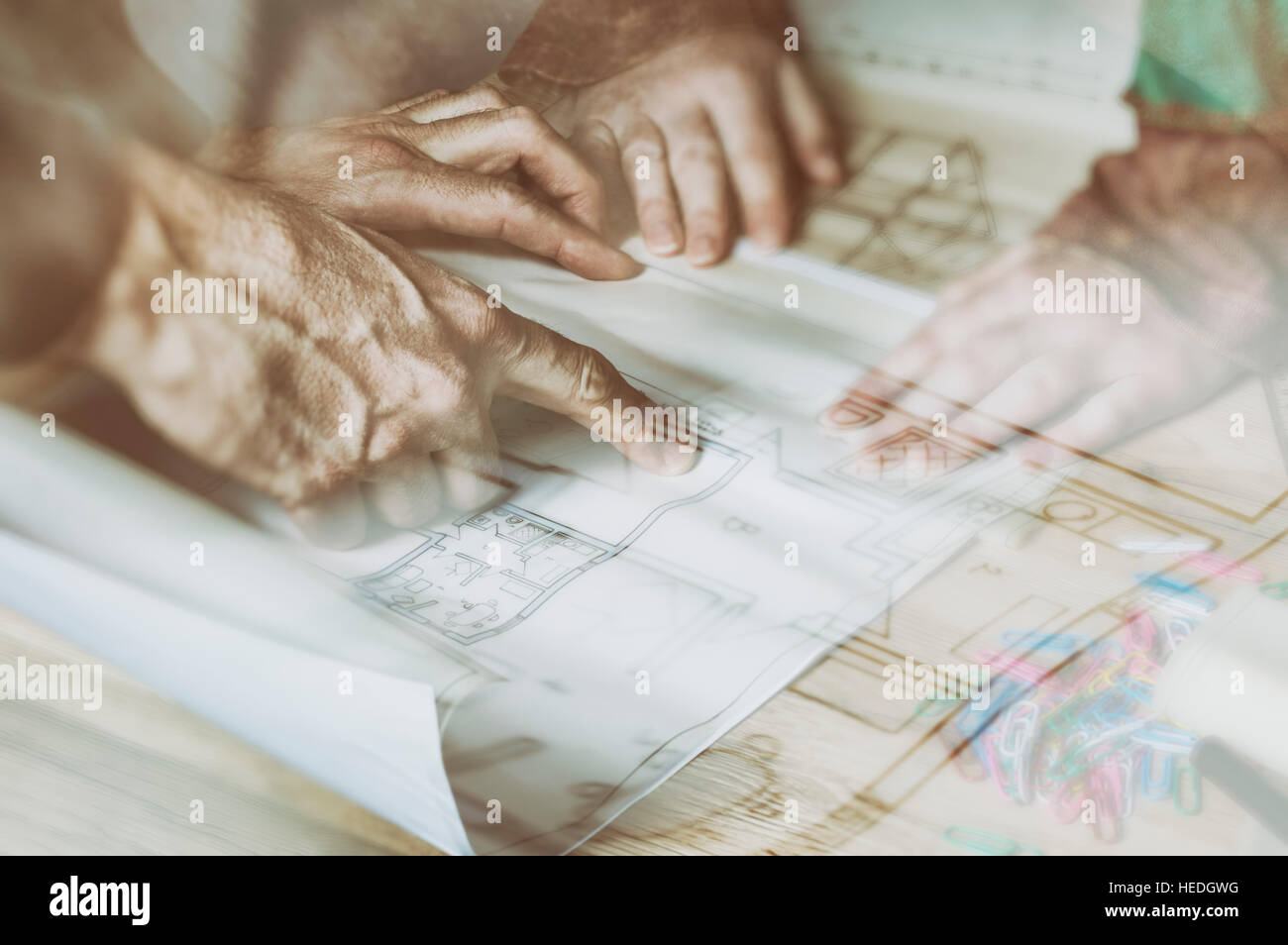 Hands of engineer working on architectural project. Construction concept. Double exposure of construction side and blueprint. Stock Photo