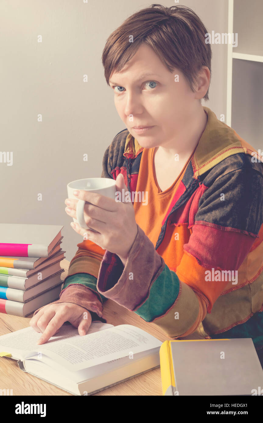Woman with a book and cup of hot drink. Education concept. Stock Photo