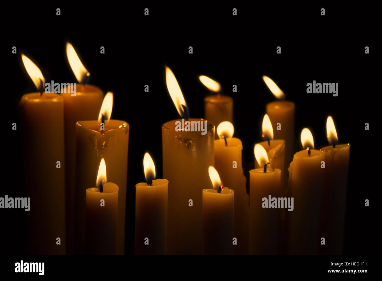 Light many candles burning in the black background Stock Photo Alamy