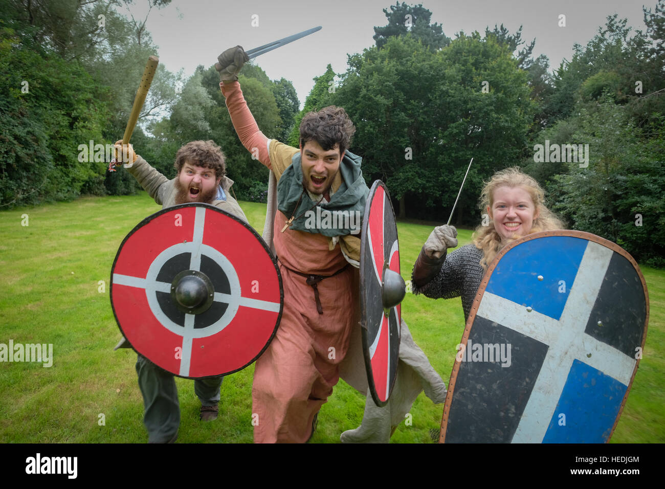 Aberystwyth University student society  - Historica Normannis (a 12th century reenactment group, focusing primarily on the events between the reign of Henry I and King John.) - three people charging and waving their swords Stock Photo