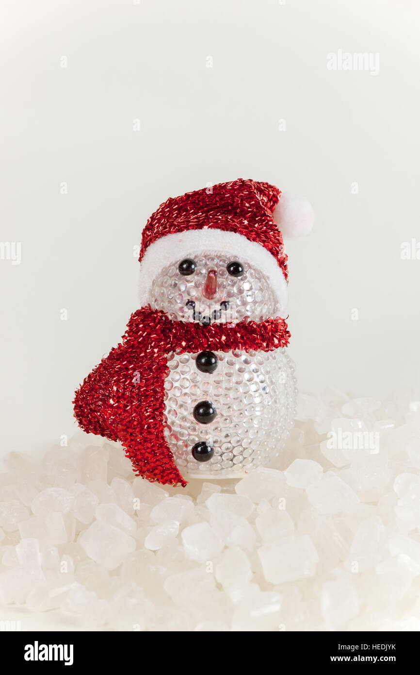 Snow Man on a pile of white crystalline with white background. Stock Photo