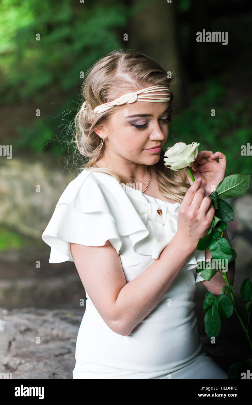 beautiful girl sniffing white rose Stock Photo - Alamy