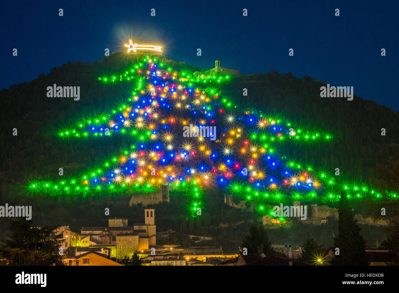 'Christmas tree' illumination on Mount Ingino above the town of Gubbio, Perugia province, Umbria region, Italy. Stock Photo