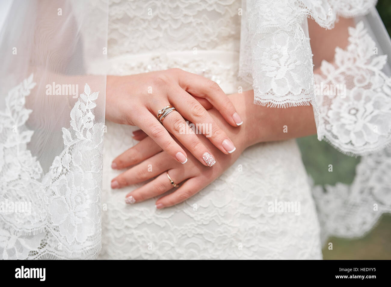 hands of bride in white dress with manicure wedding day Stock Photo