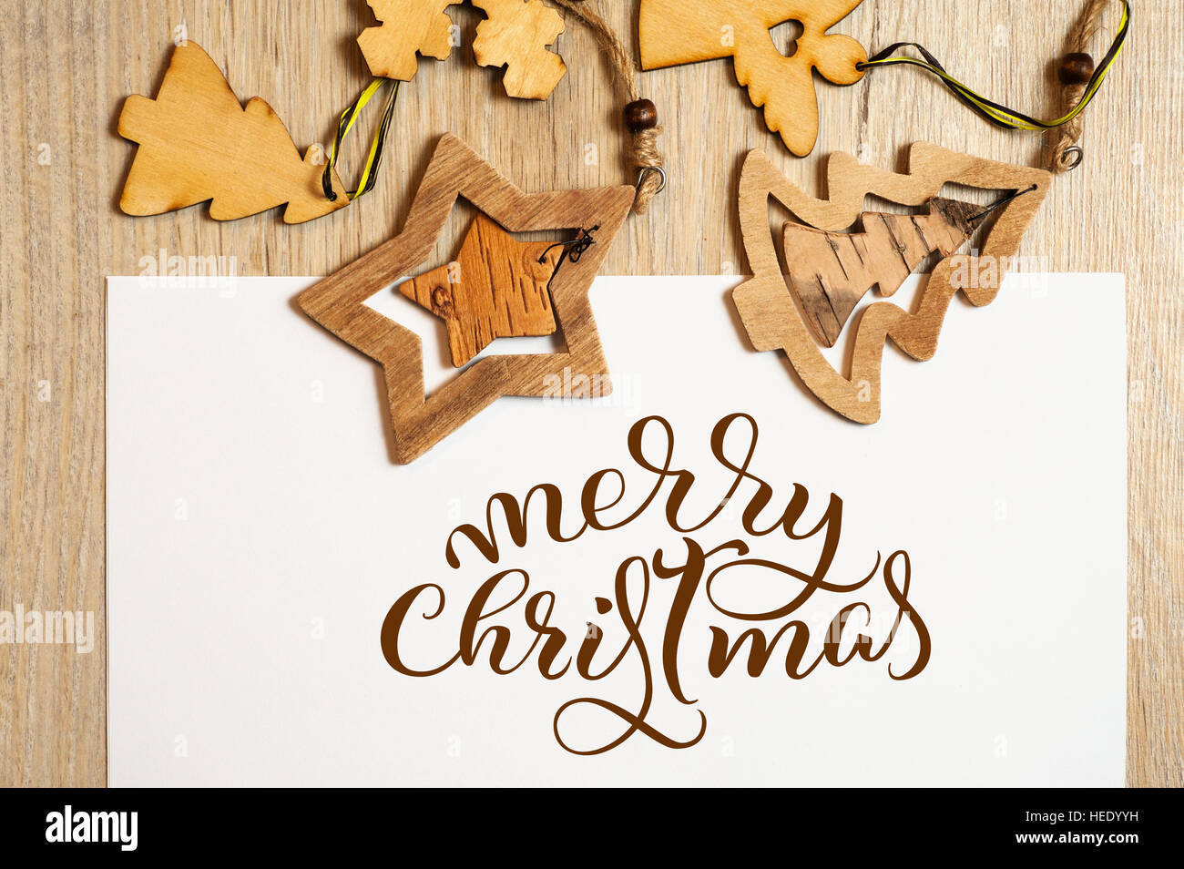 Wooden toys on white background with text Merry Christmas. Calligraphy lettering Stock Photo