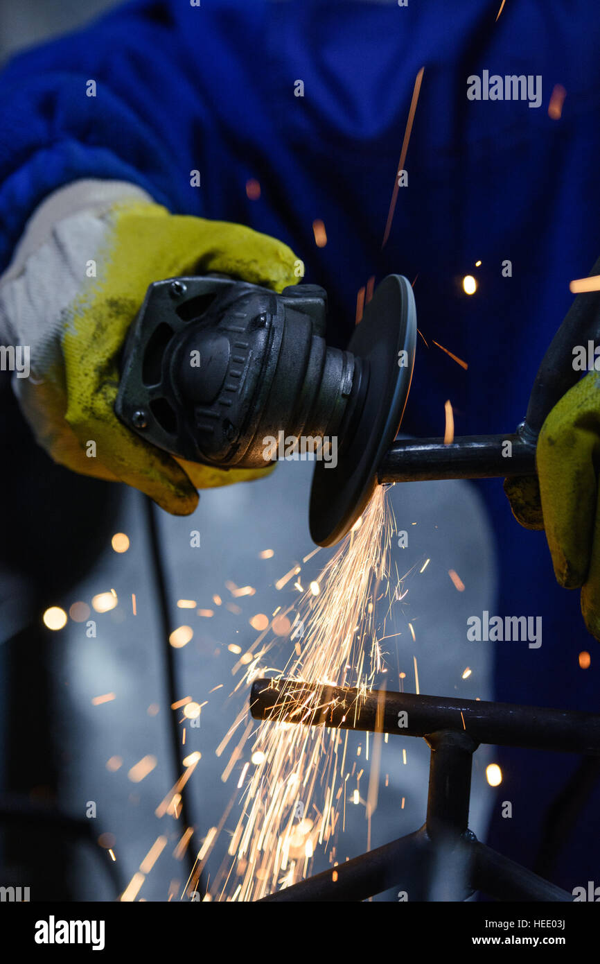 Cutting metal with angle grinder. Sparks flying while grinding pipe