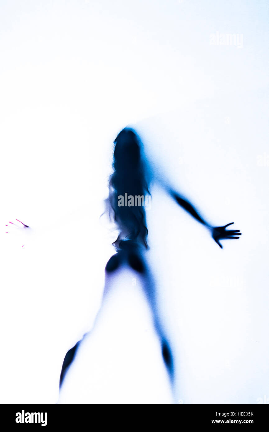 Abstract art nude : the hazy vague outline of a naked body shape of a young  woman girl standing alone behind a white gauze screen Stock Photo - Alamy