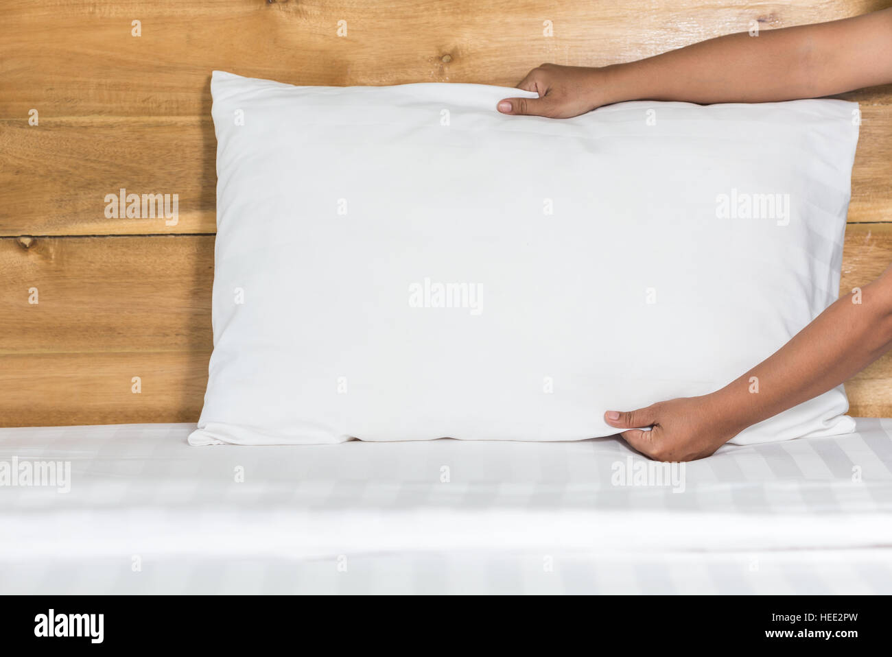Close Up Hand Set Up White Pillow On Bed Sheet In Hotel Room
