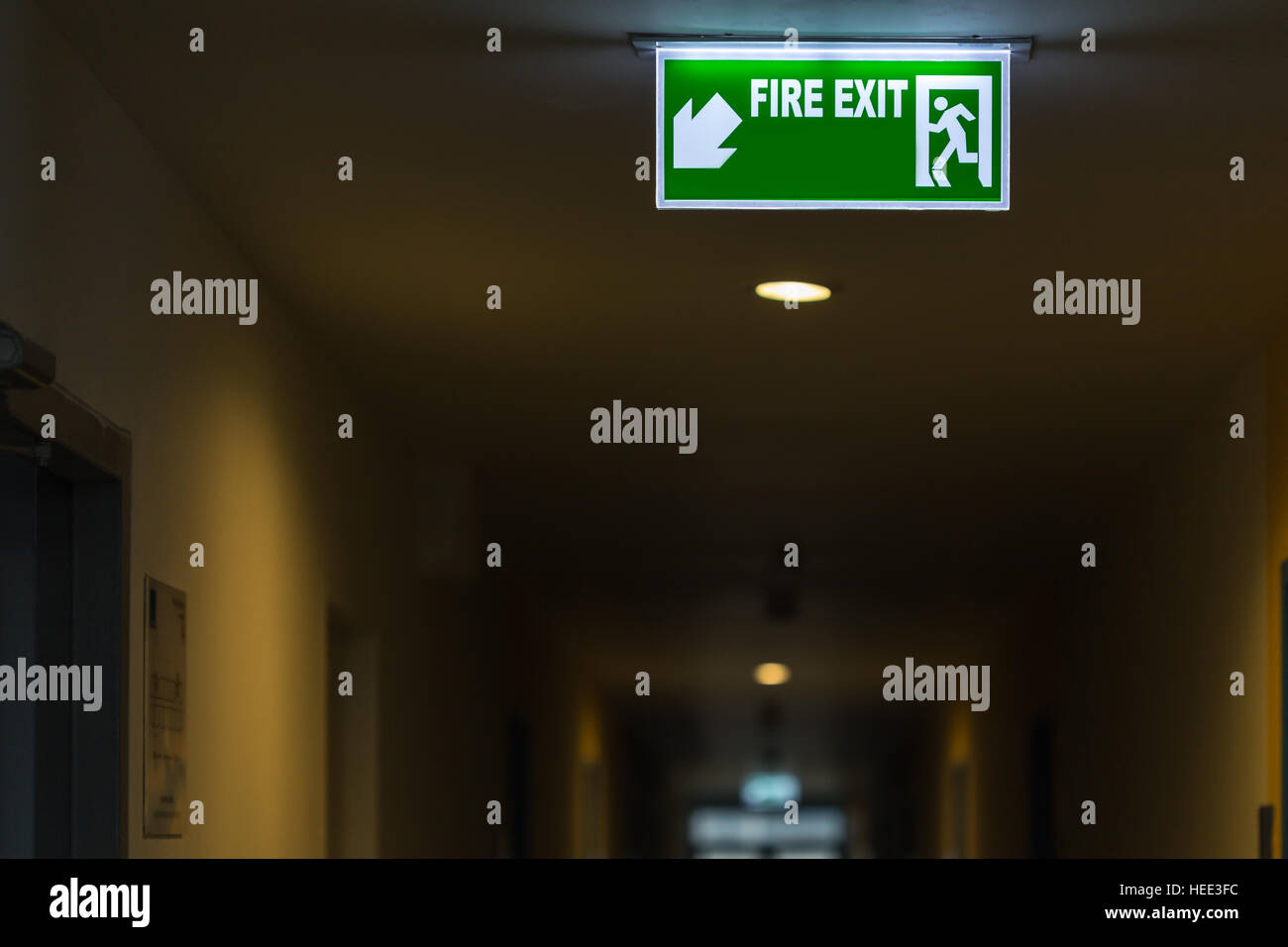 Green fire exit sign in hotel corridor Stock Photo
