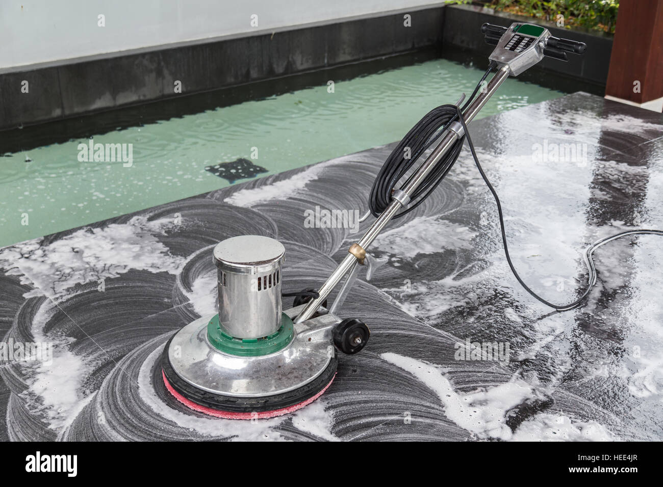 Exterior black stone floor cleaning with polishing machine and chemical