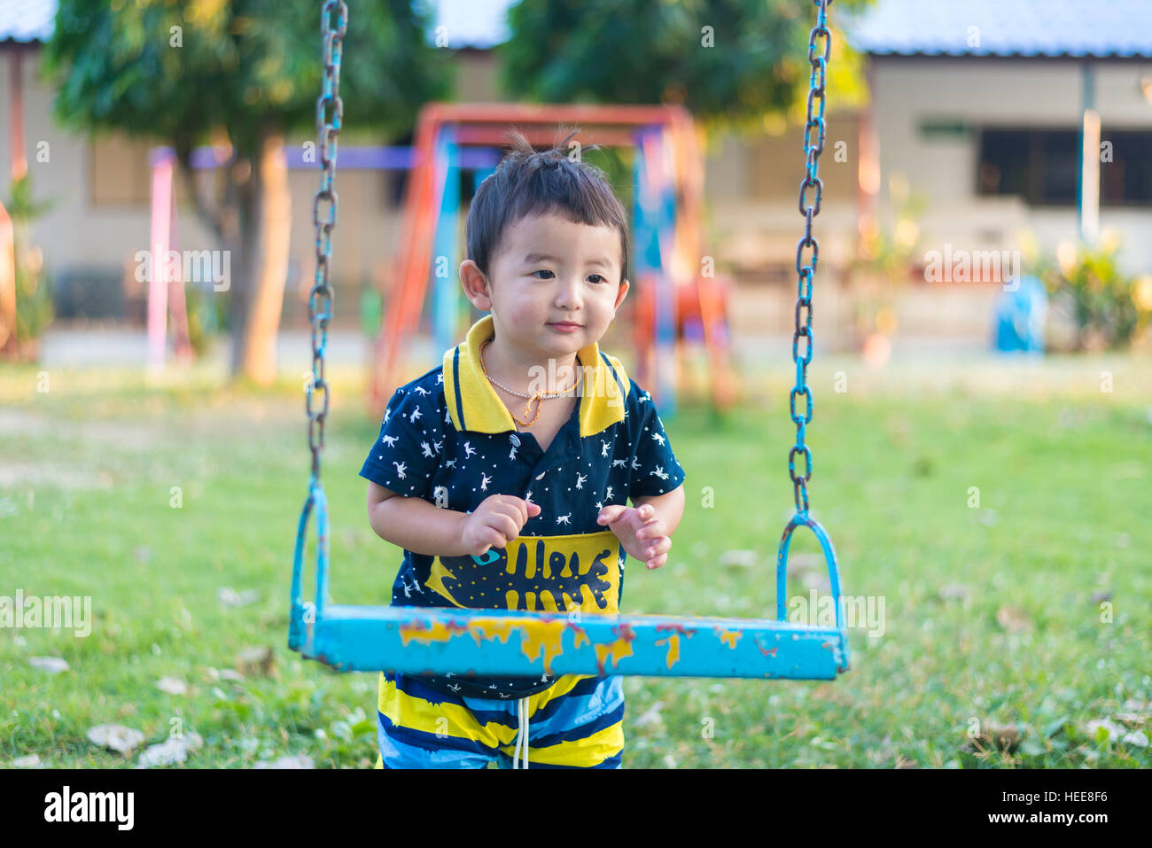 Young Asian boy play a iron swinging at the playground under the ...