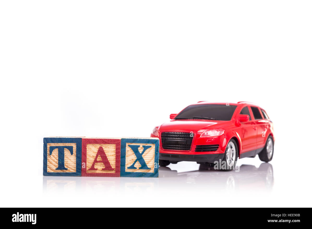TAX write in colorful wood alphabet blocks and red model car isolated on white background Stock Photo