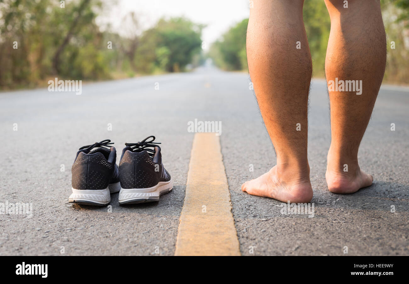 Close up legs of man with black running shoes on asphalt road in morning time Stock Photo Alamy