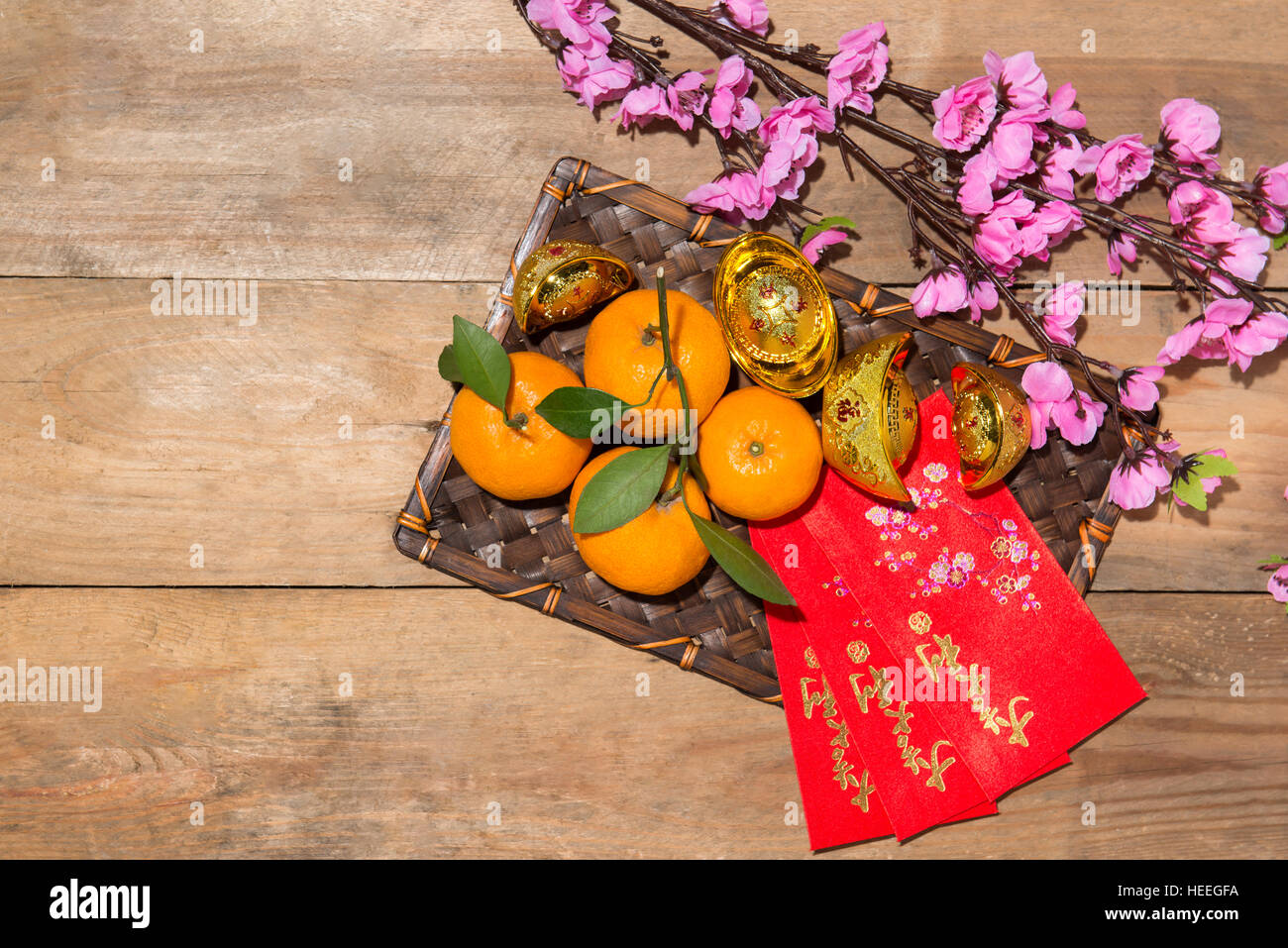 Mandarin oranges and Lunar New Year with text 'Happy New Year' on red pocket. Tet Holiday concept. Stock Photo