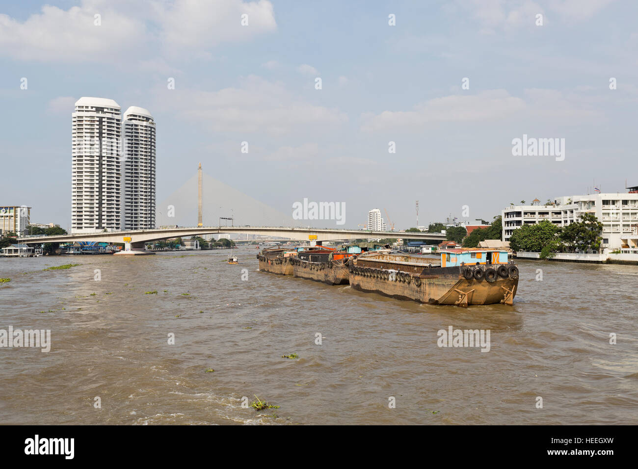 Huge empty cargo barges being towed upstream the Chao Phraya River in Bangkok, Thailand Stock Photo