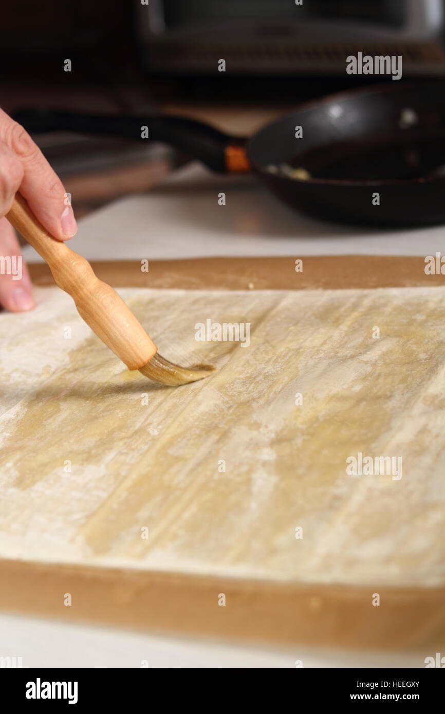Brushing sheet of filo pastry with melted butter. Making Filo Pastry