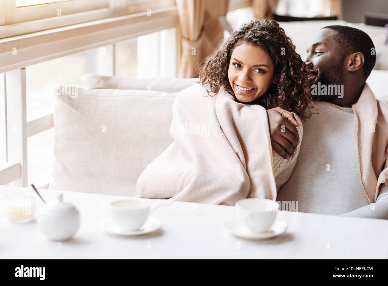 Glad young African American couple sitting in the cafe Stock Photo - Alamy