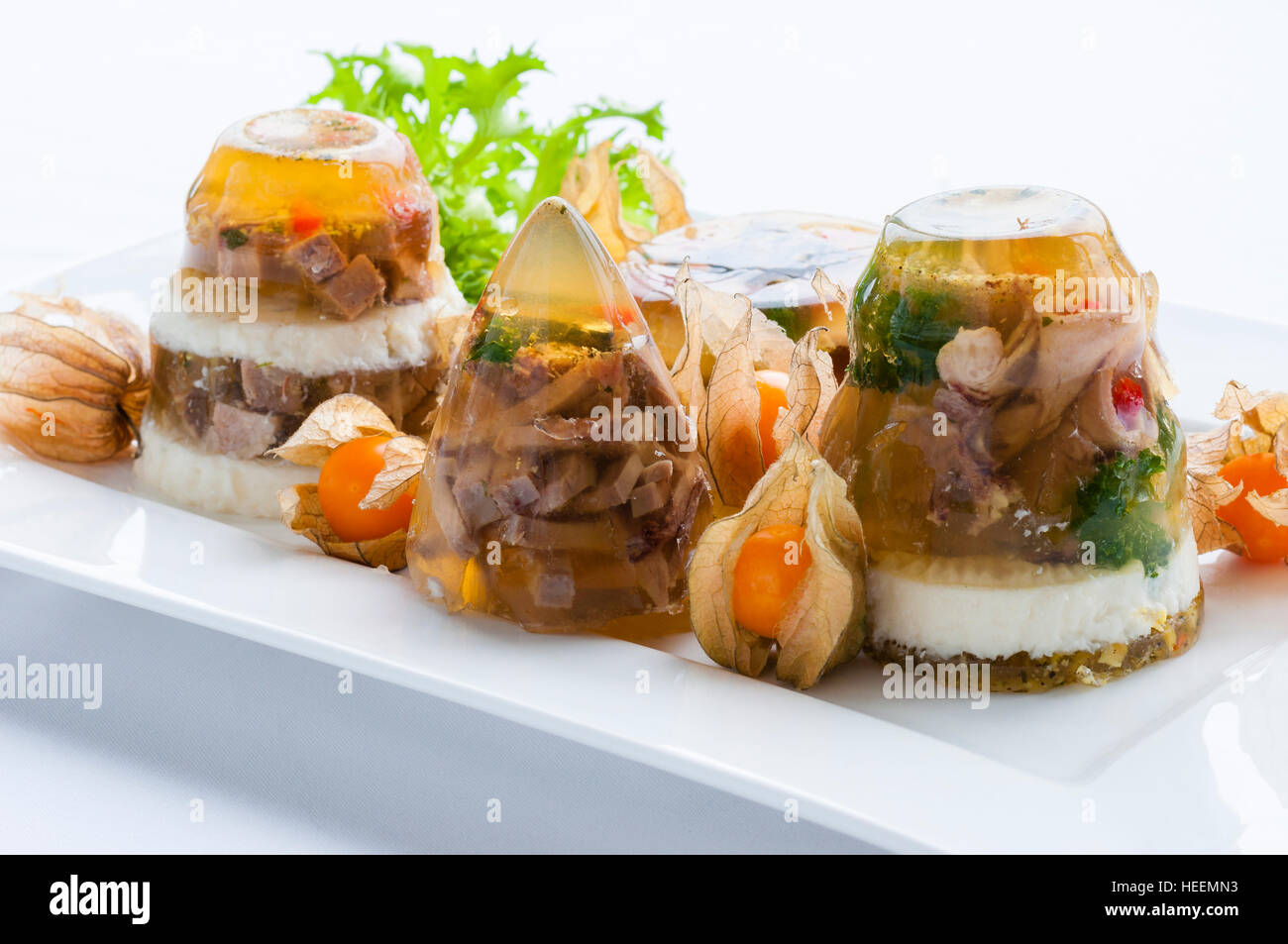 Decorated food. Aspic cold dish with meat, jelly, vegetables, greenery