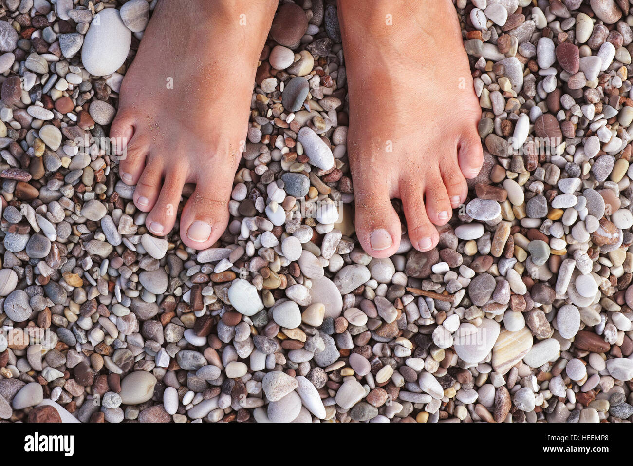 Barefoot woman standing on the pebbles or stones. Relaxation and massage.  Close up Stock Photo - Alamy