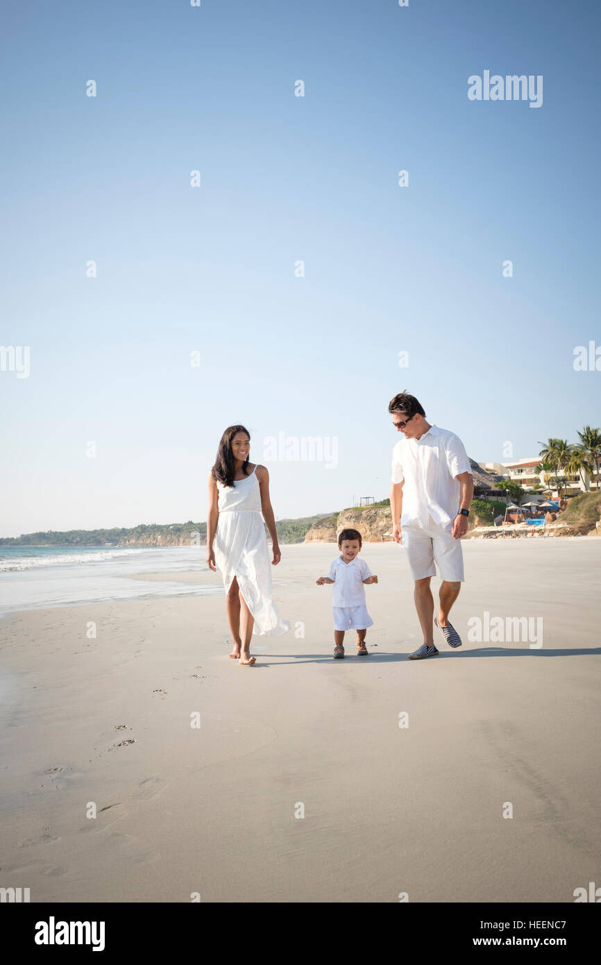 Multiethnic family of three walking at the beach. Riviera Nayarit Mexico. Stock Photo