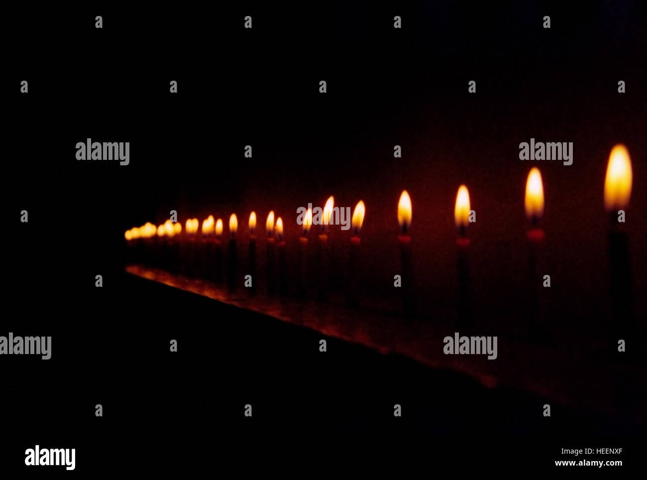 Glowing lit candles in a row Stock Photo Alamy