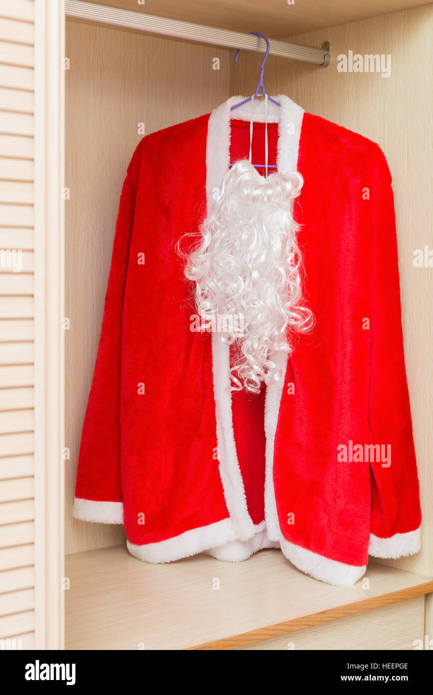 Santa Claus Coat And Beard Hanging In A Wardrobe Stock Photo