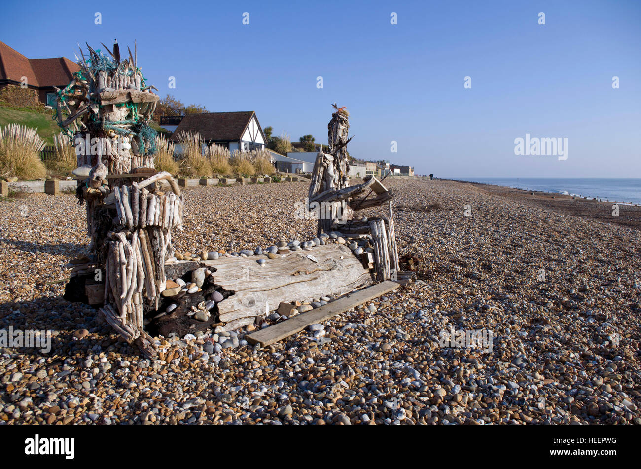 Driftwood figures on the beach at the western end of the seafront of Bexhill on Sea. Created by local artist Andy Sharrocks Stock Photo