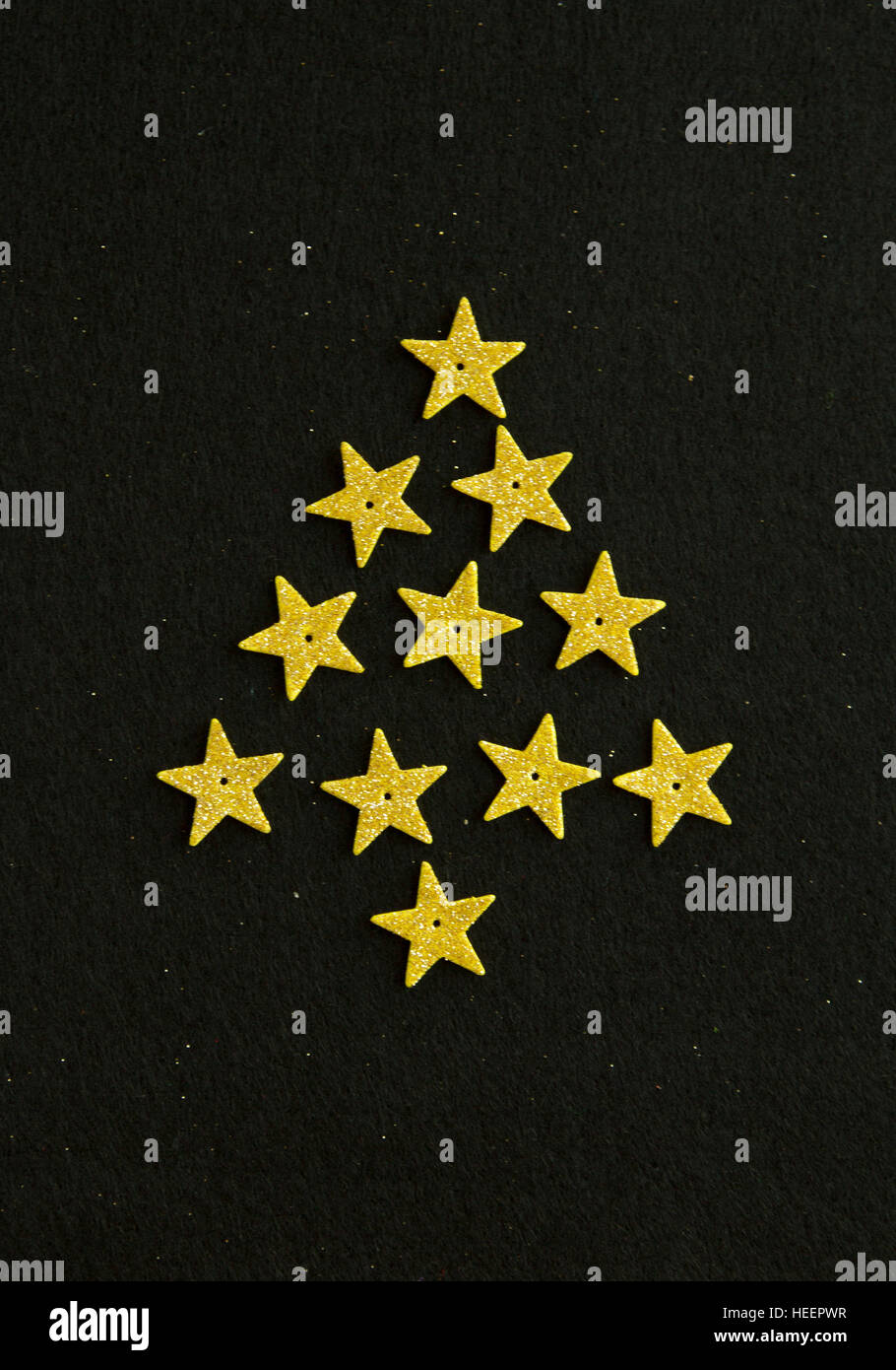 Christmas tree from small golden stars on black background Stock Photo ...