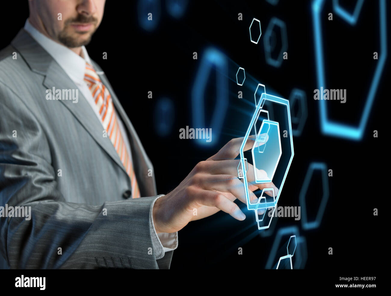 Businessman touching button on futuristic virtual screen, black background Stock Photo