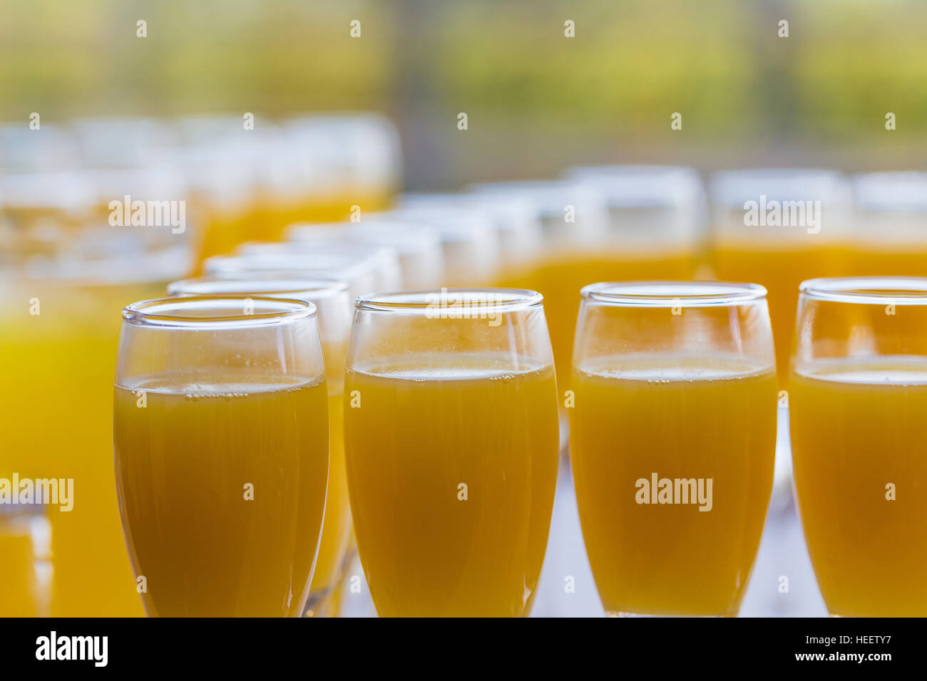 Rows of champagne glasses filled with orange juice / bucks fizz at wedding reception Stock Photo