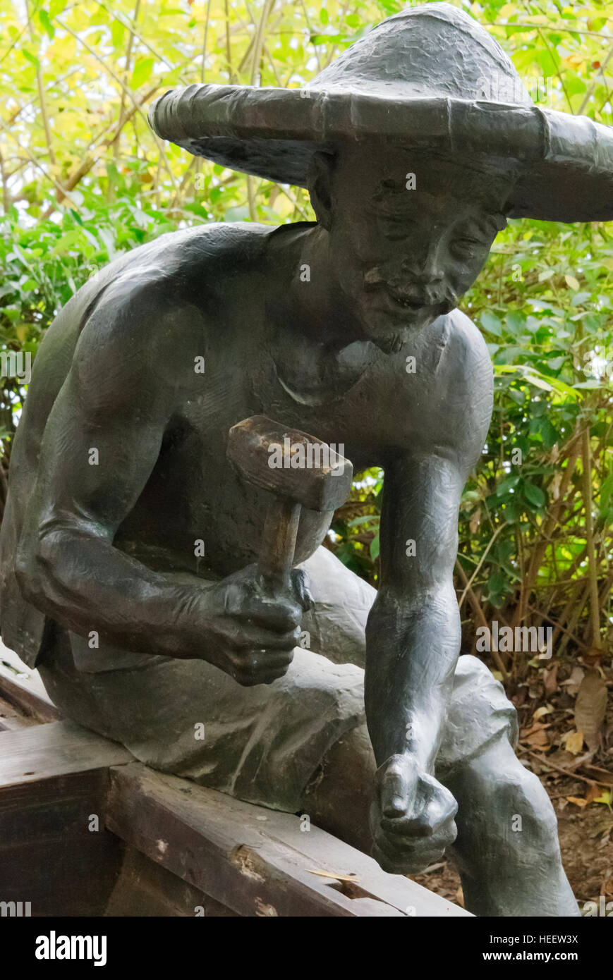 Bronze statue of man making boat, Taierzhuang Ancient Town, Shandong Province, China Stock Photo