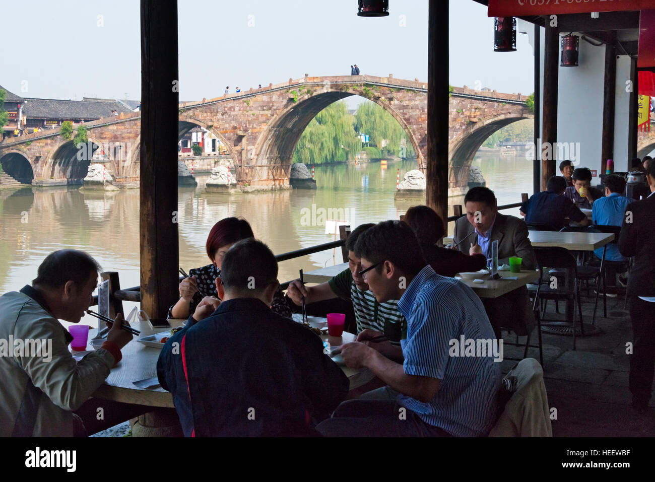 Teahouse along the Grand Canal, Guangji Bridge in the background, Tangqi Ancient Town, Hangzhou, Zhejiang Province, China Stock Photo
