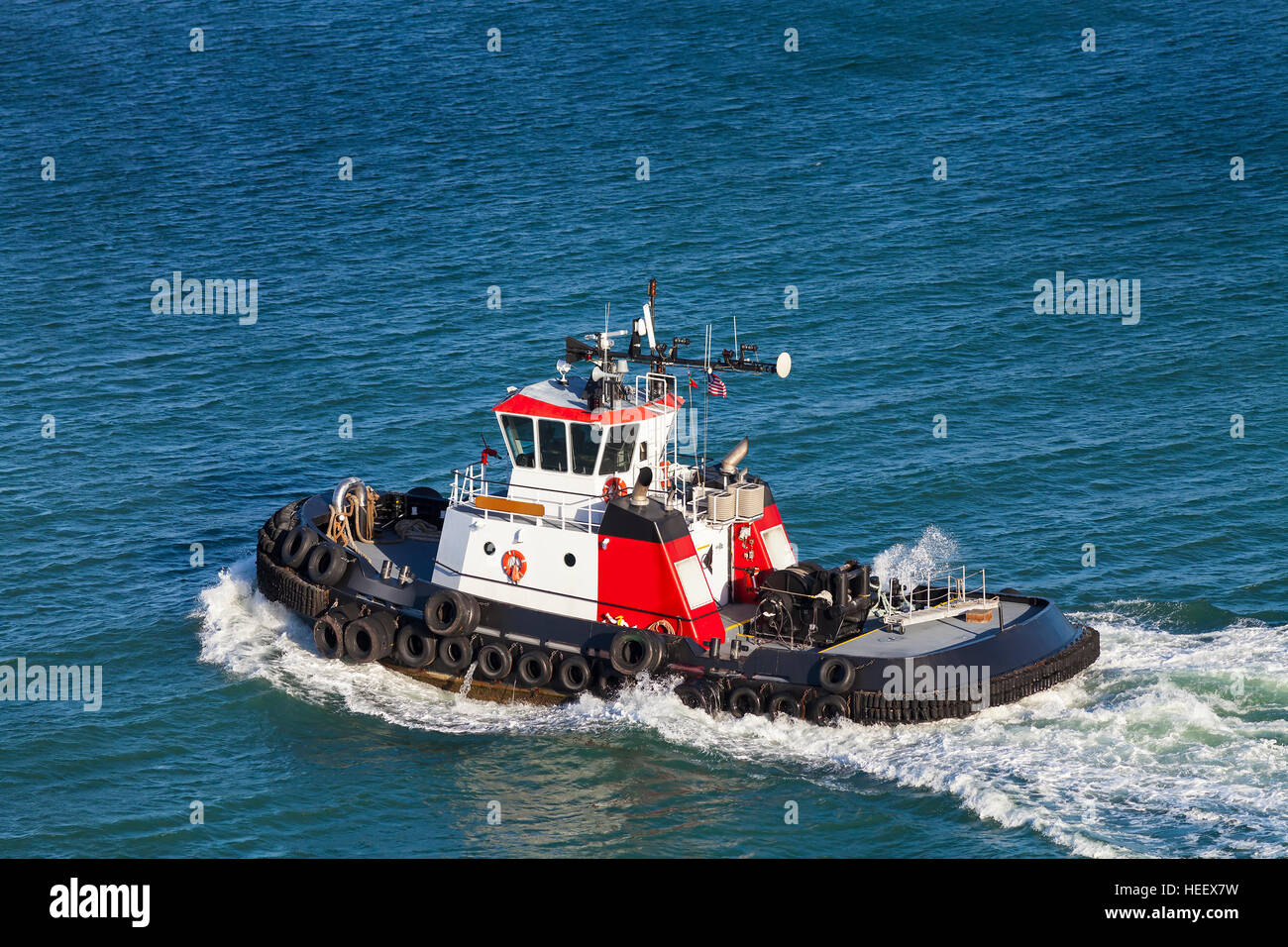 Red and White Tug Boat on the open ocean from above. Stock Photo