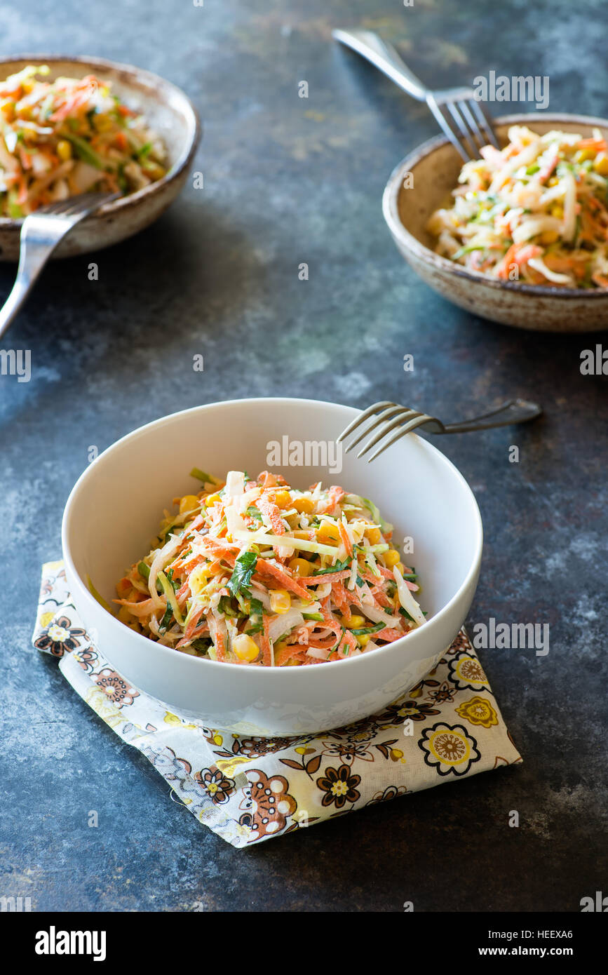 Fresh cabbage, corn and carrot coleslaw salad in bowl, mayonnaise dressing. Stock Photo
