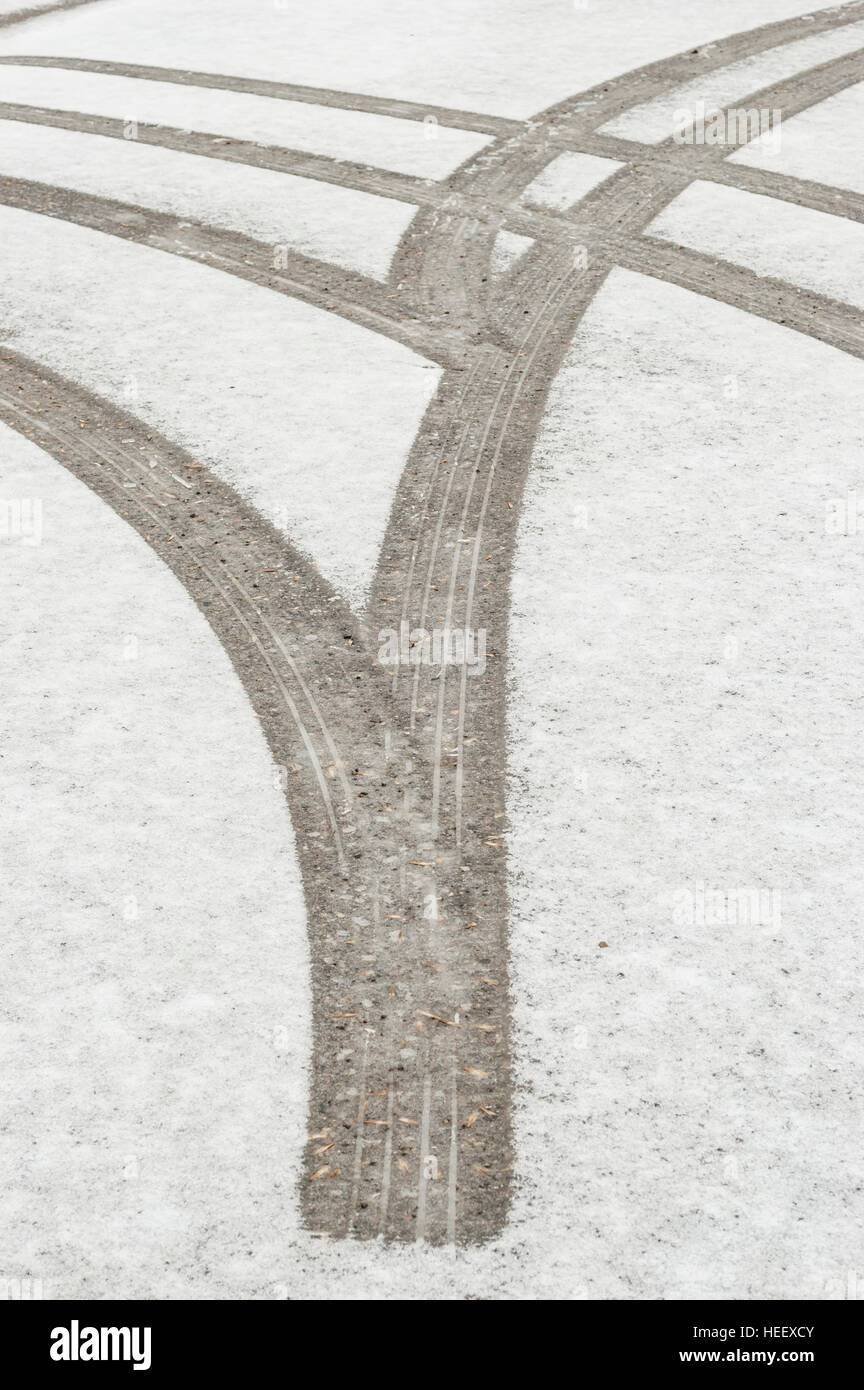 Tire tracks / markings in fresh snow on a paved road. Stock Photo