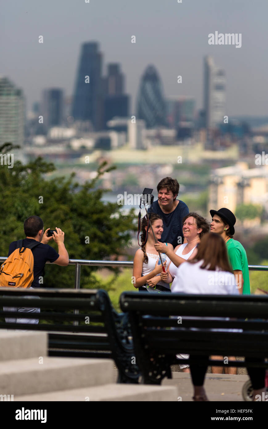 People shooting selfies in Greenwich Park with buildings of the City of London, the financial district, in the background. Stock Photo