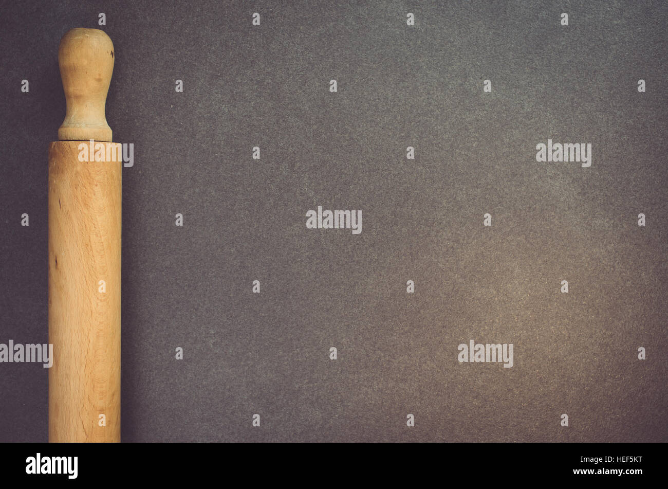 wooden cooking utensils on dark slate worktop rolling pin Stock Photo